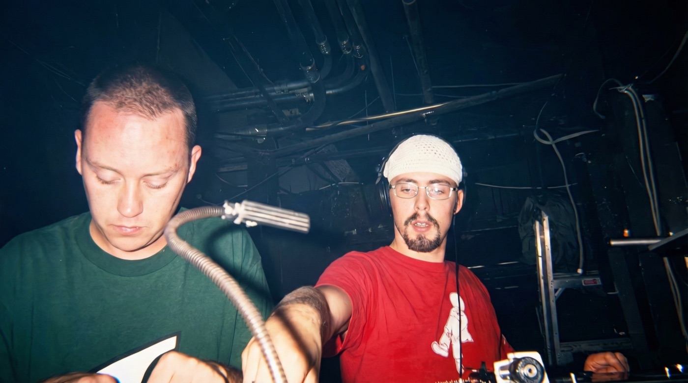 Two DJs playing together in the booth